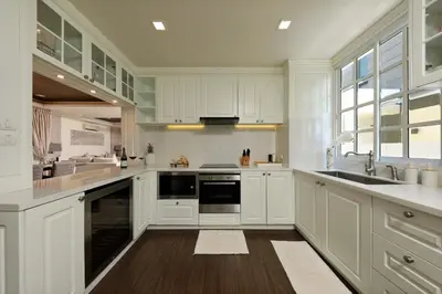 a large kitchen with white cabinets and a sink at Laguna Park Grand Villa na Bang Tao in Phuket Town