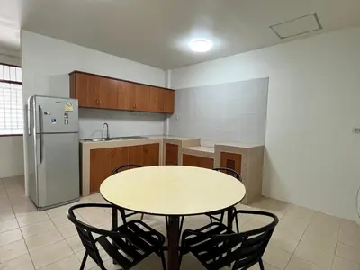 a kitchen with a table and chairs and a refrigerator at Genesis Urban Phuket in Ban Lo Long