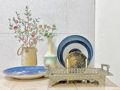 a table with a vase and a plate and a vase at Genesis Urban Phuket in Ban Lo Long
