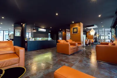 a lobby with orange leather furniture and a bar at Citygate Peaceful Condo Kamala Beach in Kamala Beach