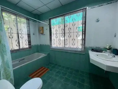 a green bathroom with a tub and a toilet and a sink at Kata Sea Blue Villa in Kata Beach