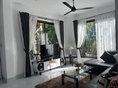 a living room with a flat screen tv and a couch at Kata Sea Blue Villa in Kata Beach