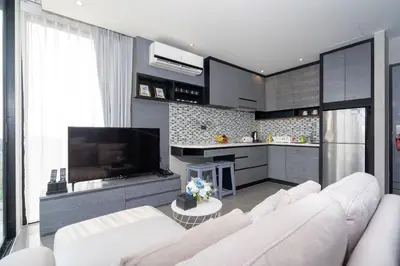 a living room with a white couch and a television at tropics Kamala CTG L604, near FantaSea & Café Del Mar Beach Club in Kamala Beach