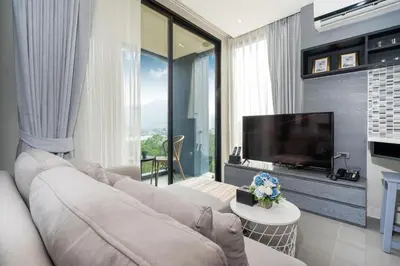 a living room with a couch and a flat screen tv at tropics Kamala CTG L604, near FantaSea & Café Del Mar Beach Club in Kamala Beach