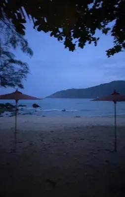 two umbrellas sitting on a beach at night at Beachfront bungalow south of Phuket in Phuket Town