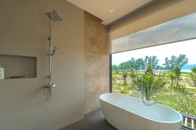 a bathroom with a tub and a large window at New 3BR Pool Villa Long One A5 with Chalong Bay view in Chalong
