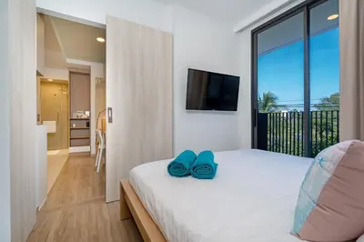 a bedroom with a bed with two blue shoes on it at SkyPark Bangtao, Laguna 2 bedroom apartment 5 minutes from the beach in Phuket Town