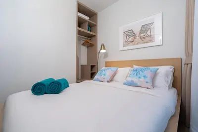 a bedroom with a large white bed with blue pillows at SkyPark Bangtao, Laguna 2 bedroom apartment 5 minutes from the beach in Phuket Town