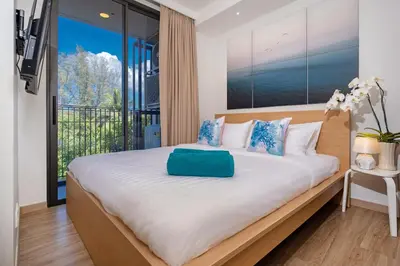 a bedroom with a large bed with a large window at SkyPark Bangtao, Laguna 2 bedroom apartment 5 minutes from the beach in Phuket Town