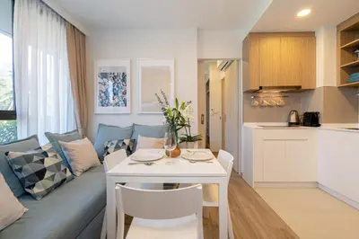 a kitchen and living room with a couch and a table at SkyPark Bangtao, Laguna 2 bedroom apartment 5 minutes from the beach in Phuket Town
