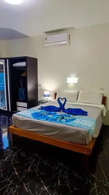 a bedroom with a bed with a blue dress on it at Kata Lina guesthouse in Kata Beach
