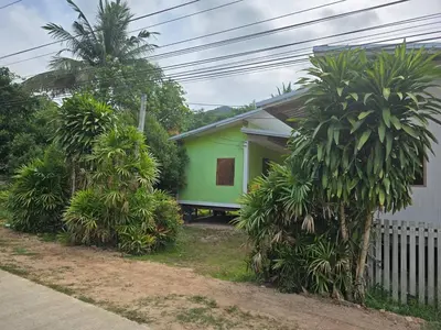a green house with trees in front of a house at Sukanyawoodhouse in Ban Tha Rua