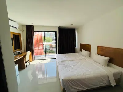 a bedroom with a bed and a view of a balcony at Jhen House in Nai Yang Beach