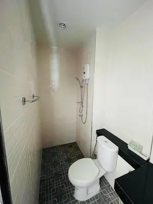 a bathroom with a toilet and a shower at Jhen House in Nai Yang Beach