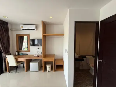a room with a desk and a table with a computer at Jhen House in Nai Yang Beach