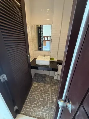 a bathroom with a sink and a mirror at Jhen House in Nai Yang Beach