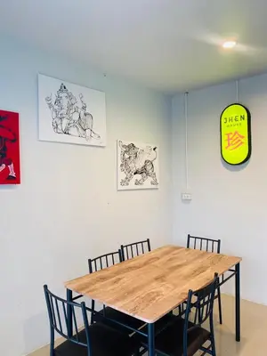 a dining room table with chairs and a clock on the wall at Jhen House in Nai Yang Beach