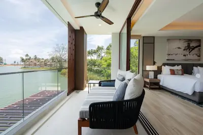 a bedroom with a bed and a view of the water at ANGSANA Oceanview Apartments with a privat pool in Laguna area in Bang Tao Beach