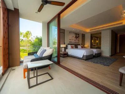 a bedroom with a king sized bed and a balcony at ANGSANA Oceanview apartments with jacuzzi in Laguna area in Bang Tao Beach