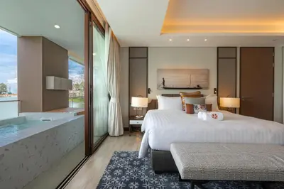 a hotel room with two beds and a bathtub at ANGSANA Oceanview apartments with jacuzzi in Laguna area in Bang Tao Beach
