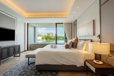 a bedroom with a large bed and a large window at ANGSANA Oceanview apartments with jacuzzi in Laguna area in Bang Tao Beach
