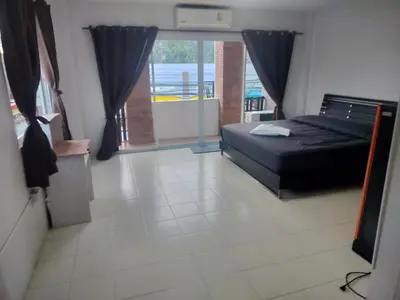 a bedroom with a bed and a large window at the three pyramids in Rawai Beach