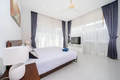 a bedroom with a white bed and a television at Villa in Ravai , 2 bedrooms in Ban Saiyuan (1)