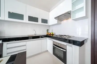 a kitchen with white cabinets and black counter tops at Villa in Ravai , 2 bedrooms in Ban Saiyuan (1)