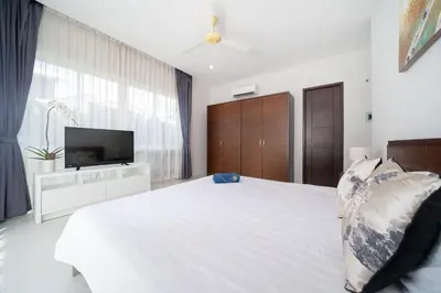 a bedroom with a white bed and a tv at Villa in Ravai , 2 bedrooms in Ban Saiyuan (1)