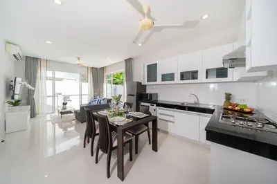a kitchen and living room with a table and chairs at Villa in Ravai , 2 bedrooms in Ban Saiyuan (1)