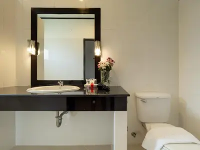 a bathroom with a sink and a mirror at Isara Nai Yang resort in Nai Yang Beach