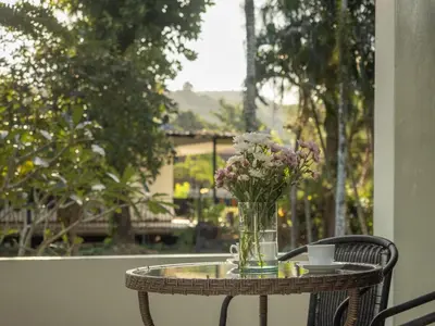 a glass table with a vase of flowers on it at Isara Nai Yang resort in Nai Yang Beach
