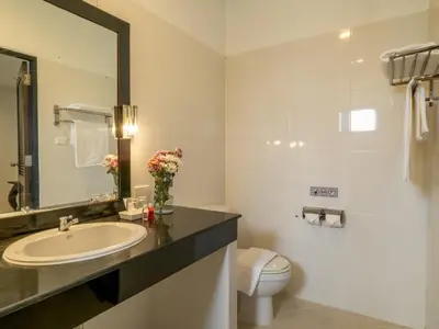 a bathroom with a sink and a toilet and a mirror at Isara Nai Yang resort in Nai Yang Beach