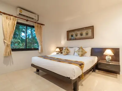 a bedroom with a bed and a window at Isara Nai Yang resort in Nai Yang Beach
