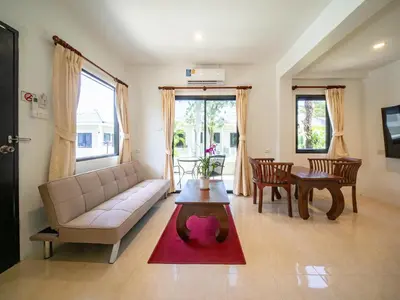 a living room with a couch and a table at Isara Nai Yang resort in Nai Yang Beach