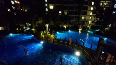 a large swimming pool with people in it at night at Bright Apartment Close to Amazing Beach ! 39 Sqm in Nai Yang Beach