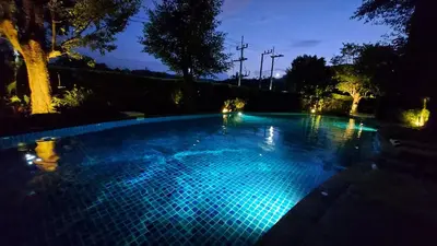 a swimming pool lit up at night with blue lights at Bright Apartment Close to Amazing Beach ! 39 Sqm in Nai Yang Beach