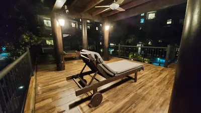 a rocking chair sitting on a deck at night at Bright Apartment Close to Amazing Beach ! 39 Sqm in Nai Yang Beach