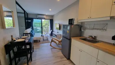 a kitchen with a refrigerator and a table and a dining room at Bright Apartment Close to Amazing Beach ! 39 Sqm in Nai Yang Beach