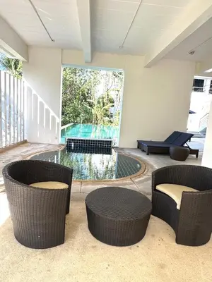 a living room with two chairs and a swimming pool at Apartment Karon 62 sq in Karon Beach