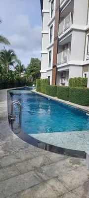 a swimming pool in front of a building at Title V in Rawai Beach