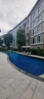 a building with a swimming pool in front of a building at Title V in Rawai Beach