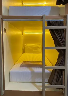 a bunk bed in a room with a yellow wall at LONGDOO Hostel in Phi Phi Don