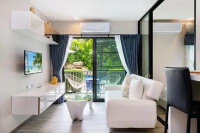 a living room with a white couch and a balcony at F12 Номер Люкс Бассейн Рубль ВАТСАП669З582I976 in Nai Yang Beach