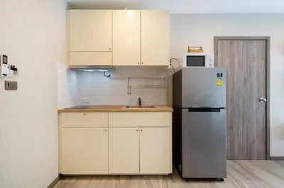 a kitchen with white cabinets and a refrigerator at F12 Номер Люкс Бассейн Рубль ВАТСАП669З582I976 in Nai Yang Beach