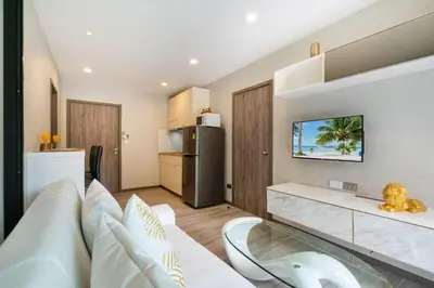 a living room with a white couch and a kitchen at F12 Номер Люкс Бассейн Рубль ВАТСАП669З582I976 in Nai Yang Beach