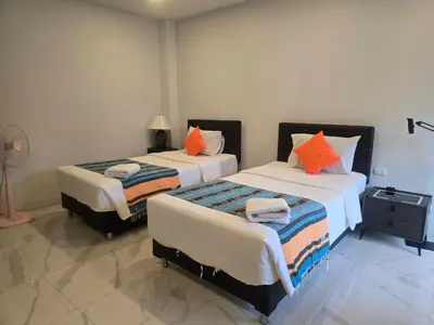 a bedroom with two beds with orange pillows at PR ROOM FOR RENT in Kamala Beach