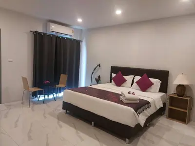 a bedroom with a large bed with pink pillows at PR ROOM FOR RENT in Kamala Beach