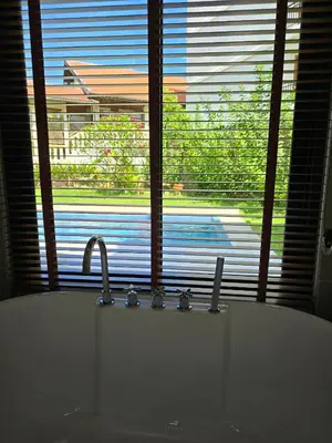 a bathroom with a sink and a window with a tub at PoolVilla 234 Patong in Patong Beach