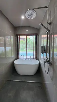 a bath tub in a bathroom with a window at PoolVilla 234 Patong in Patong Beach